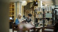 Pengunjung sedang membaca buku di perpustakaan (Foto Times Surabaya)
