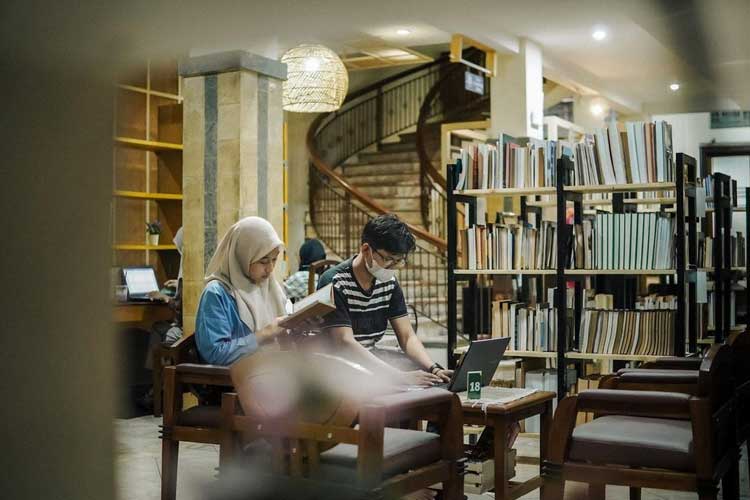 Pengunjung sedang membaca buku di perpustakaan (Foto Times Surabaya)