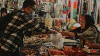 Pedagang dan pembeli sedang bertransaksi di sebuah pasar (Foto Fisipol UGM)